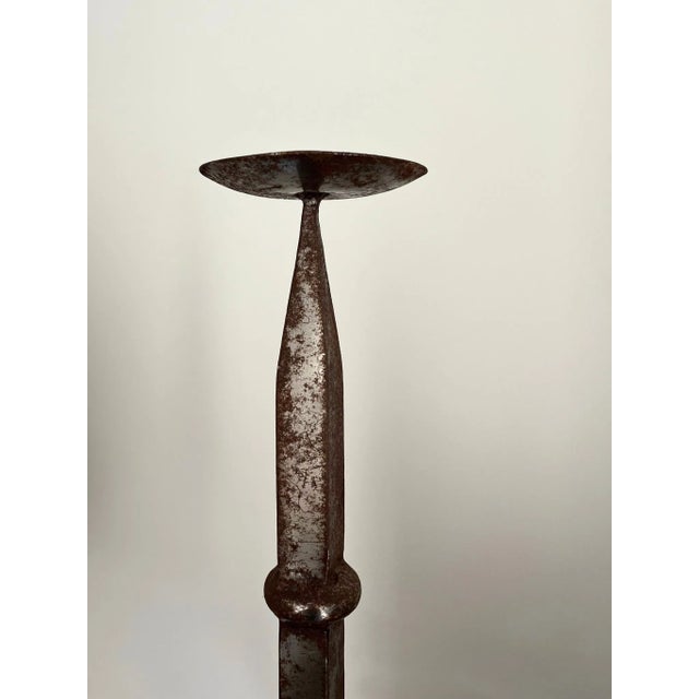 A solid chunky heavyweight french iron pricket candlestick with great patina and a brutalist aesthetic, supported on...