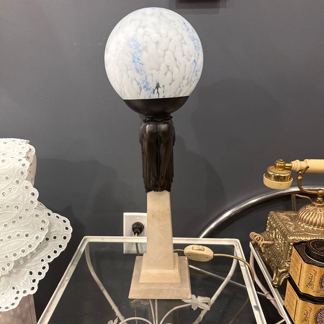Striking vintage Art Deco Revival figural table lamp featuring a bronze-tone Egyptian-inspired female figure seated atop...