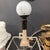 Striking vintage Art Deco Revival figural table lamp featuring a bronze-tone Egyptian-inspired female figure seated atop...