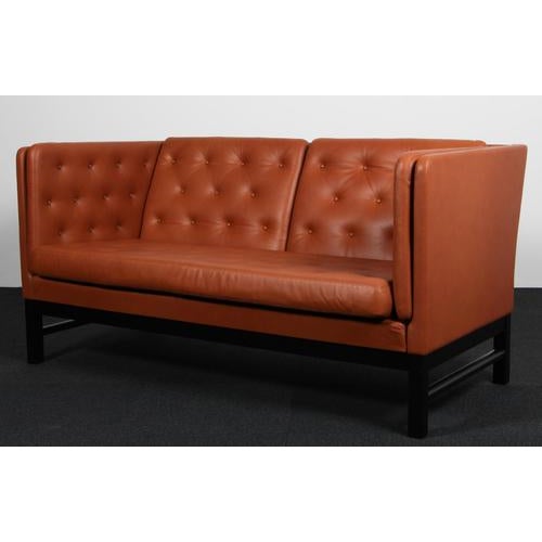 Erik Jørgensen two-seat sofa new upholstered with cognac pure aniline leather. Frame of black painted beech. Model EJ...