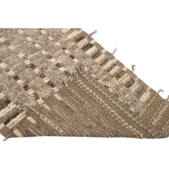 Beautiful Moroccan style handmade wool rug with a brown field. This Modern rug has beige and gray accents and beige-brown...