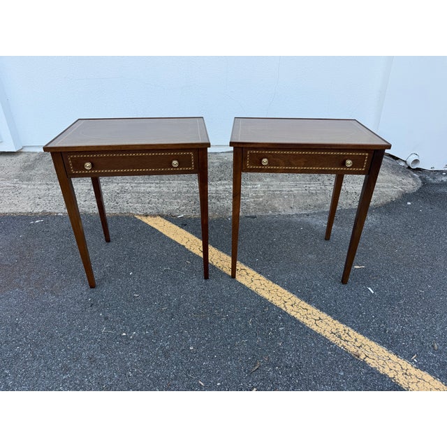 Pair of Federal style inlaid mahogany side tables . They feature with tapered legs, a single dovetailed drawer, a slightly...