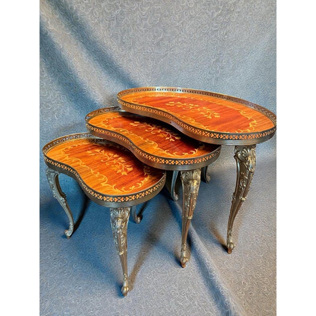 Exceptionally beautiful set of three interlocking side tables in an elegant kidney shape. The legs are richly decorated...
