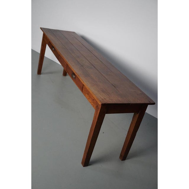 This elegant table was made from pitch pine circa 1950 in France. The table shows many signs of use and age and has a warm...