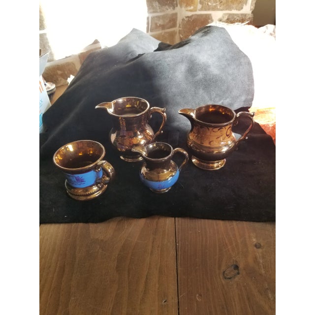 Four 19th century English copper luster ceramic pieces. One pitcher has some cracks.