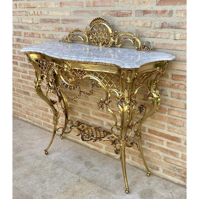 Italian Mid-Century Marble Top and Bronze Console This 1960s Italian console table has a brass frame with cornucopia and...