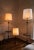 A sculptural mid-century floor lamp that pairs light with a place to set things down. A weighted, patinated metal base...