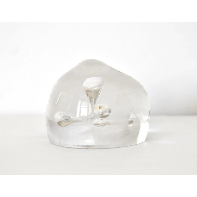 A vintage hand-blown glass clear paperweight with 5 interior bubbles pointing to the center.