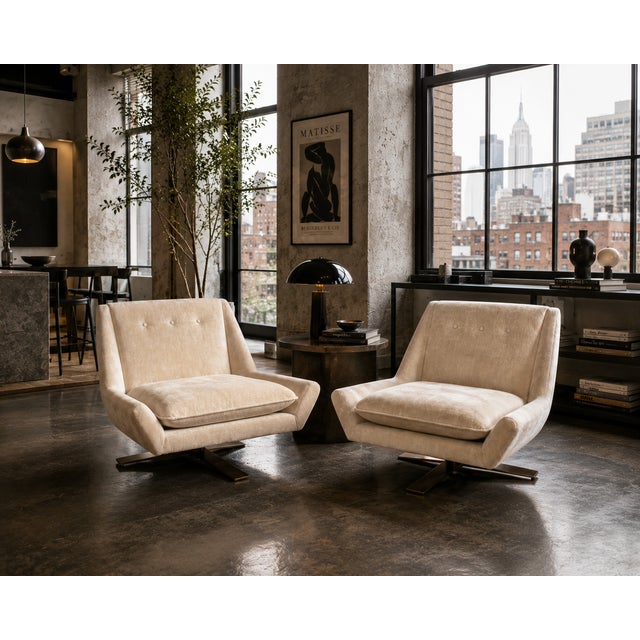 A sophisticated pair of Vioski swivel lounge chairs designed in 2004 and upholstered in luxurious champagne-toned mohair....