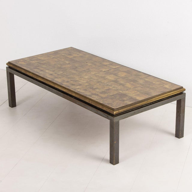 Mid century coffee table by French Maison Jansen, created with solid bronze. The tops is finished with mirrored églomisé...