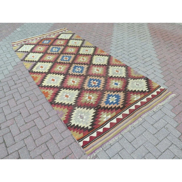 This beautiful, traditional vintage, flatweaved Turkish kilim rug is approximately 60 years old. It is handmade of very...