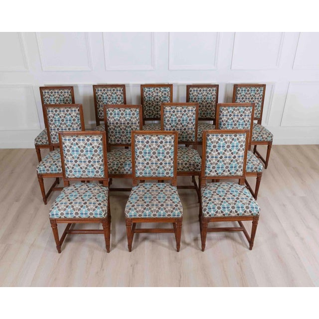 A handsome suite of twelve Louis XVI style dining chairs, crafted with elegant neoclassical lines and beautifully...