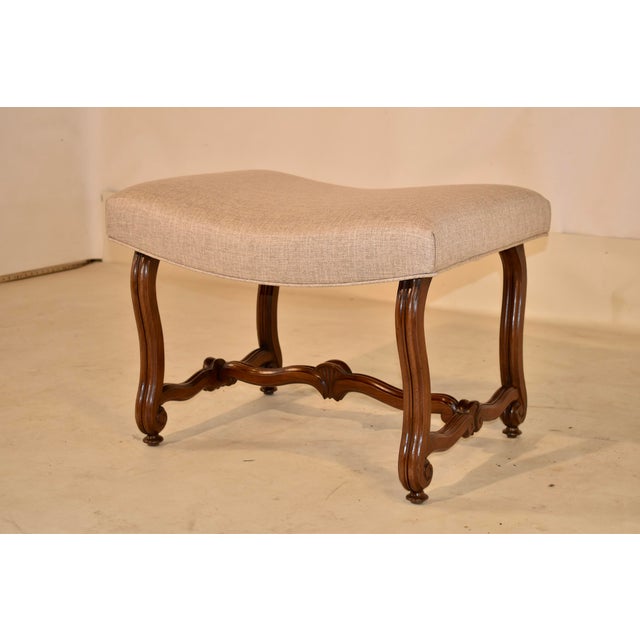 19th century walnut stool from France. The top has been newly upholstered in linen and finished with a single welt. The...