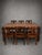 A stunning handcrafted antique Indian dining set consisting of a large solid wood dining table and six matching chairs....