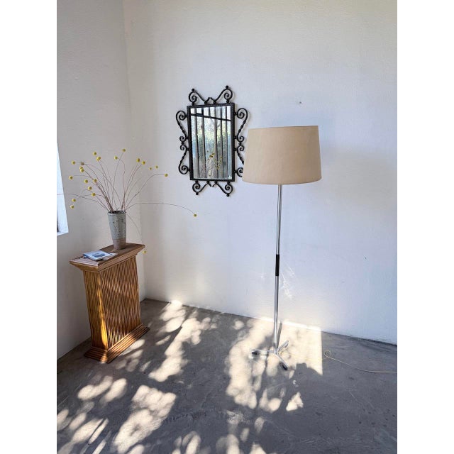 Vintage floor lamp with a chromed metal tripod base and black plastic details. In the style of Alain Richard's designs. A...