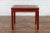 A Chinese Qing Dynasty period side table from the 19th century, with red lacquer, woven rattan top, horse hoof legs and...