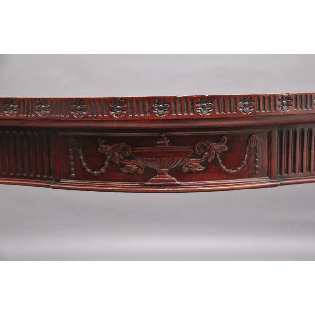 Early 20th Century mahogany serpentine console table in the Adam style, the wonderfully figured top above a fluted frieze,...