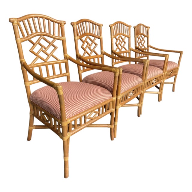 A group of four rattan armchairs by Lexington Furniture, featuring geometric fretwork backs and warm honey-toned bamboo-...