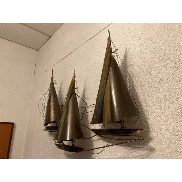 A very fine and rare brutalist brass wall art sculpture of sail boats by Curtis Jere, signed and dated 1977.