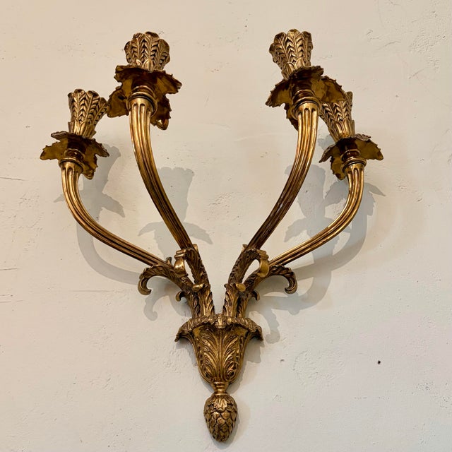 A striking and exceptionally substantial vintage Rococo Revival/Hollywood Regency brass four-arm wall sconce featuring...