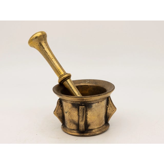 This early 20th-century mortar and pestle made of brass with an honest patina. Both the mortar and pestle are traditional...