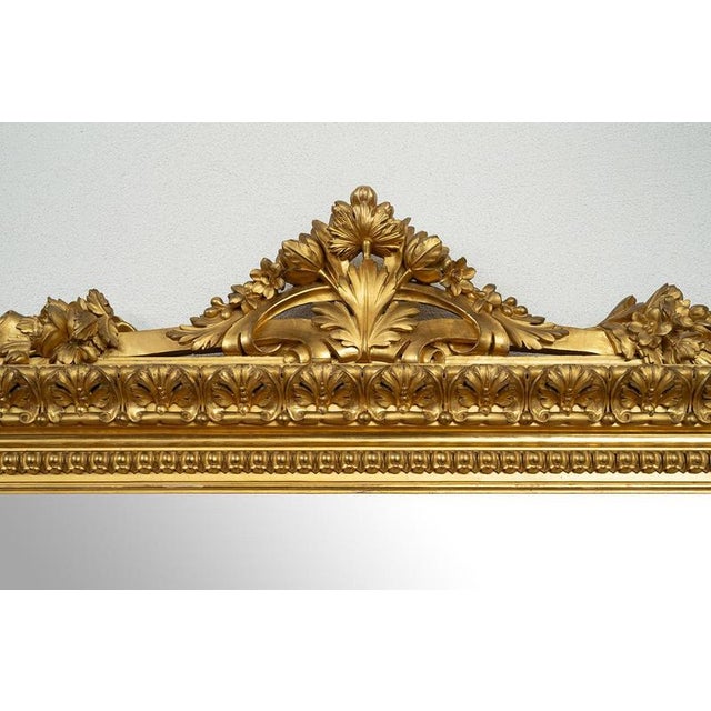 Antique Roman mirror in gilded, carved wood dating from the early 19th century. The mirror features a complex molded frame...
