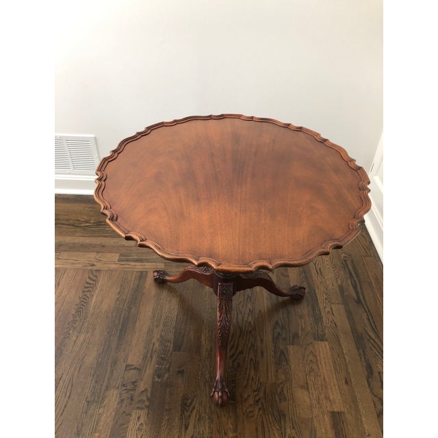 Chippendale mahogany tea table - the top with molded, scrolling edge tilting over a square birdcage, the stand is crisply...