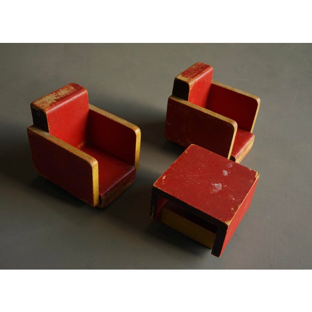 Two miniature club chairs and a side table (each piece carrying company labels and burnished markings) Table: 12 x 11.7 x...