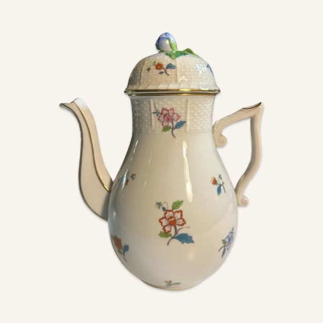 This Herend porcelain “Mille Fleurs” tea set consists of colorful hand painted flowers scattered over a white field. The...