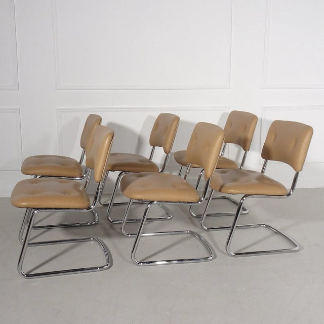 Vintage modern cantilever tubular chrome side chairs upholstered in a camel faux leather with a complimentary camel...