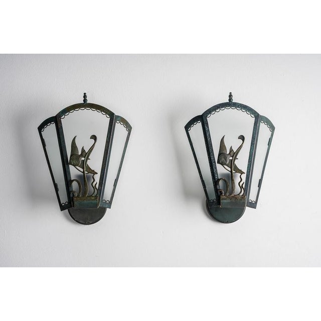 Decorative pair of Swedish Art Deco wall lights executed in bronze-patinated brass with frosted glass panels. The design...