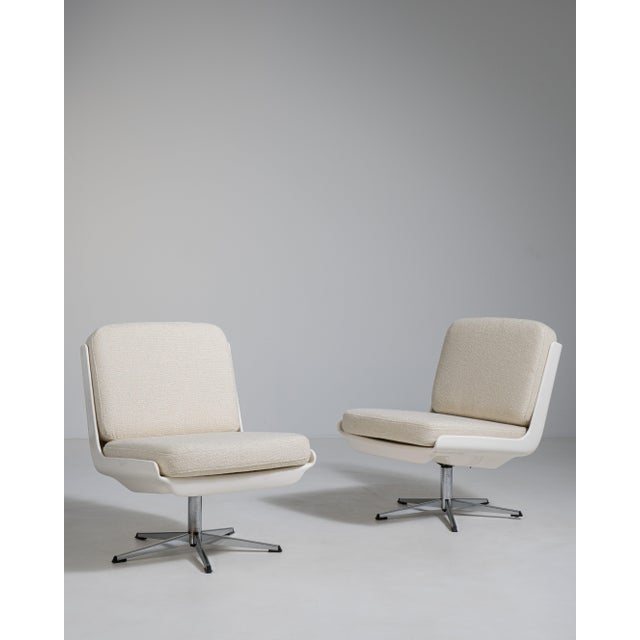 A collection of mid-century Space Age swivel chairs characterized by rounded forms and functional bases. These chairs...