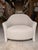 Contemporary barrel lounge chair featuring a sculptural silhouette upholstered in a soft ivory textured fabric for a warm,...