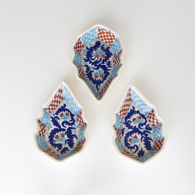 Three ceramic Turkish snack dishes feature turquoise and burnt orange checkers and royal blue scrolling foliage an d...