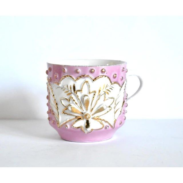 An antique, German porcelain mustache mug or cup, in porcelain with a wave base and ornate floral and dotted texture on...