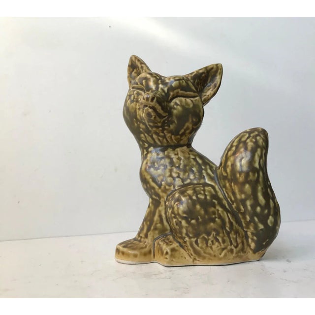 This charming ceramic fox figurine has an applied soft and subtle olive green glaze on a pastel yellow under-glaze. It was...