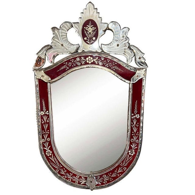 A beautiful Venetian mirror in ruby red. The mirror is U-shaped, and features applied and etched pieces of mirror in...