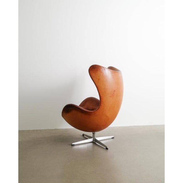 A very rare and beautiful example of an iconic danish mid century "3317 / egg" armchair in original cognac brown leather...