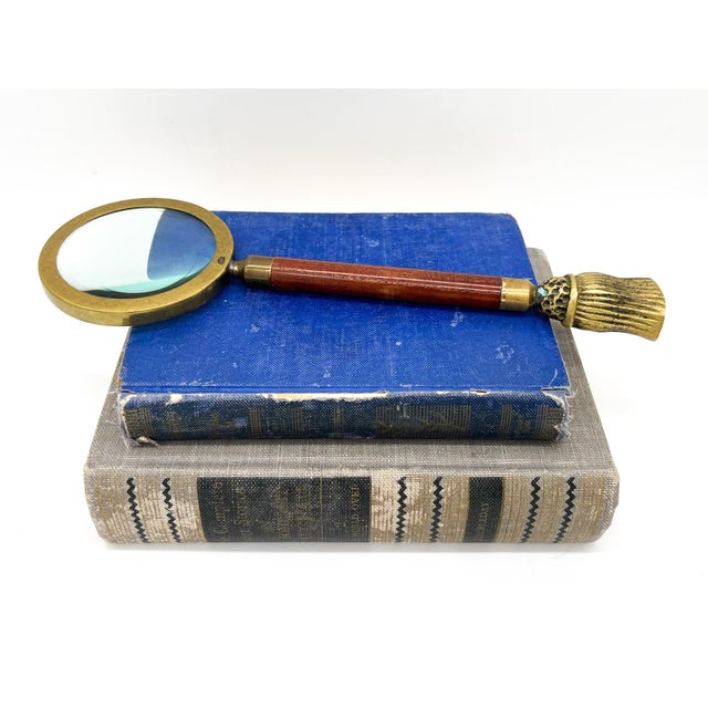 Charming and unique magnifying glass made in the mid-late 20th century. Features a wooden handle that ends in a tassel...