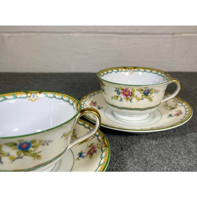 Multicolor floral with brown and green border. C. 1931. (2) Cups- 4.25”L x 3.75”W x 2.25”H (2) Saucers- 5.5”