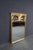 Louis XVI style rectangular mirror with an ornate giltwood frame featuring a central acanthus leaf urn, crossed rifles,...