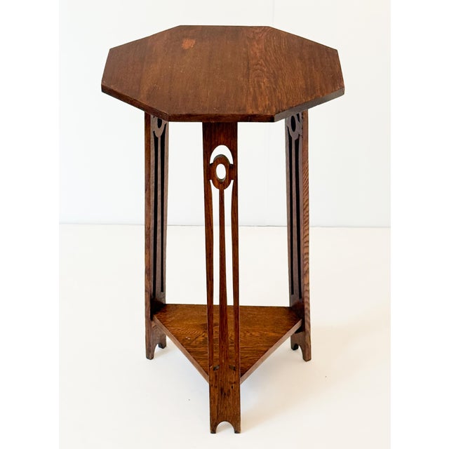 A fine English occasional or side table of oak from the Arts and Crafts Period, featuring a octagonal moulded top over a...
