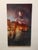 Daydream depicts a serene and contemplative figure superimposed over a softly illuminated Venetian landscape at dusk. The...