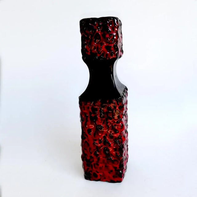 This square-shaped vase is made of red ceramic. Zauli's engraved signature can be found under the base. It was published...