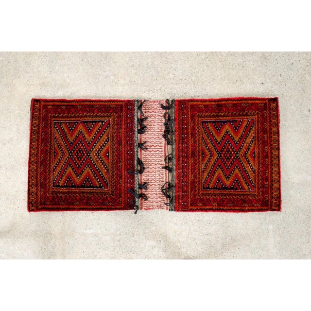 This authentic vintage Baluch tribal saddlebag rug is from a region near present-day Afghanistan and Pakistan. This small...