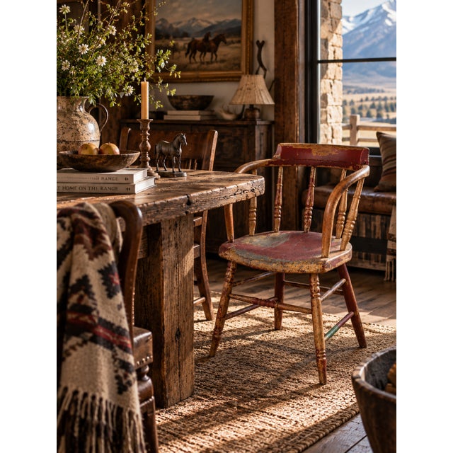 A distinctive antique captain’s chair with an expressive sculptural form and beautifully timeworn red-painted surface. The...