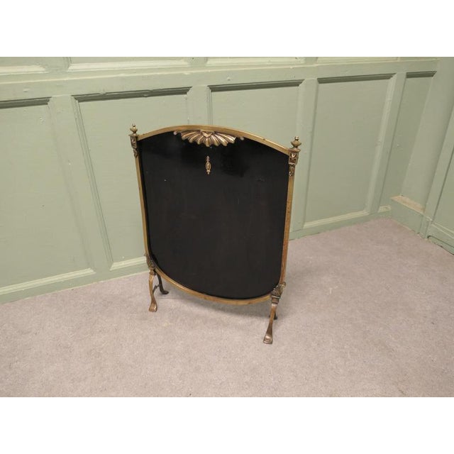 This is a charming screen, the black screen is set in a brass frame, it has a small design to the top and it is set on...