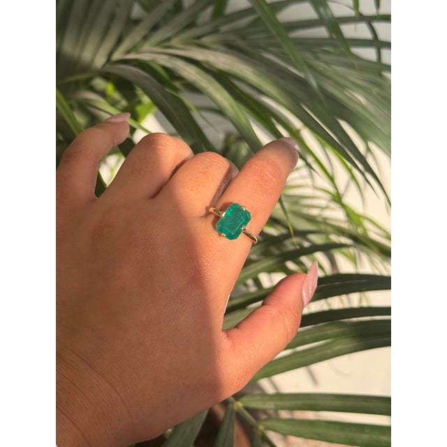 This elegant ring features a 4.58 carat emerald cut natural emerald, beautifully set in a classic four-prong solitaire...