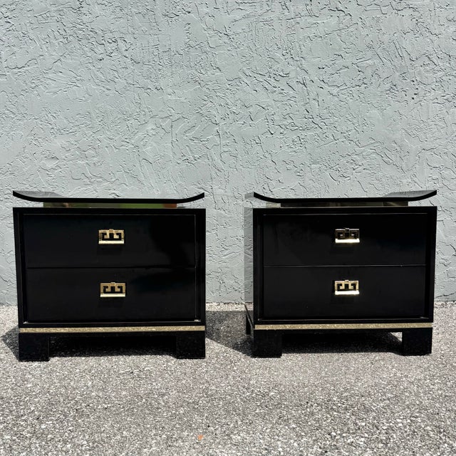 Elegant pair of chinoiserie-inspired nightstands featuring a dramatic black gloss laminate finish accented with polished...