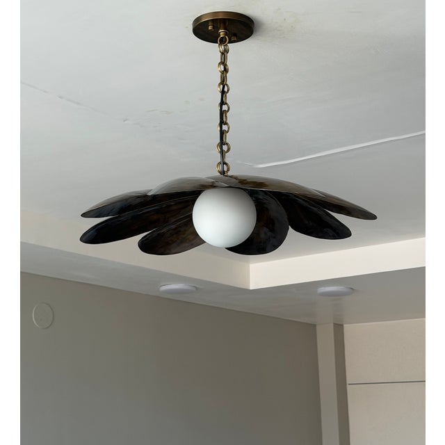 Add a warm, artistic statement to your space with this handmade black antique brass pendant light. Featuring sculptural...
